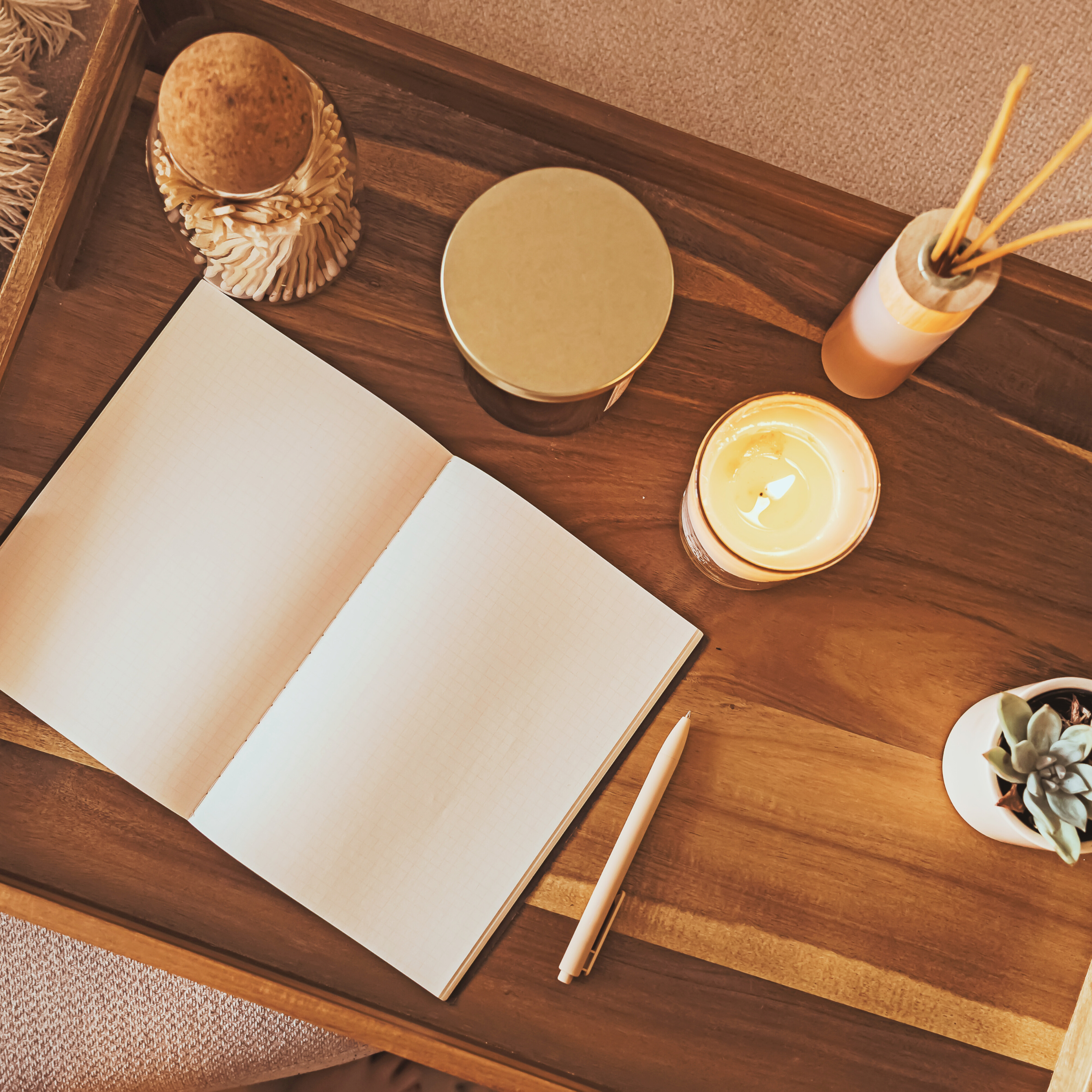 Cozy journaling table with open notebook, candle, and potted plant — calm mindful moment inspired by Natural(ish) Life.