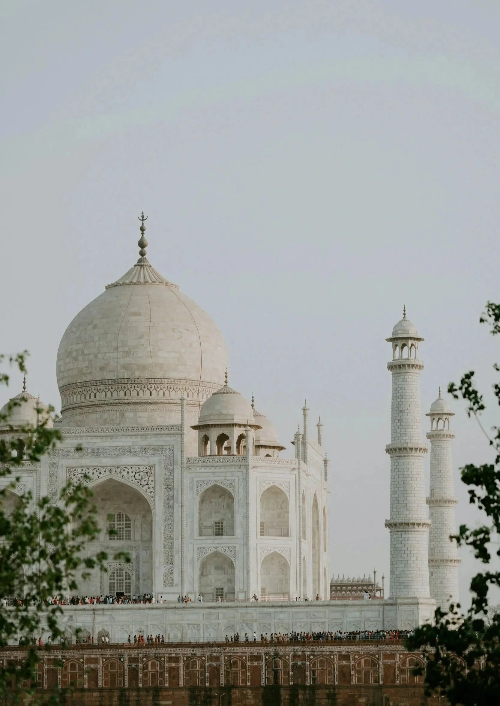 The Taj Mahal, a white marble mausoleum with a large central dome and tall minarets on either side.
