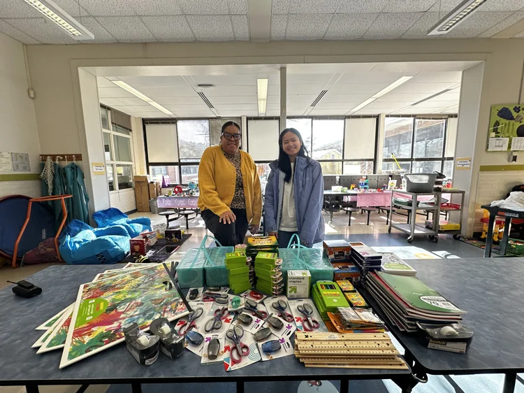 Volunteers with a table full of donated school supplies