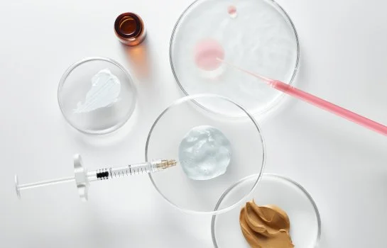 Tubes à essai et seringue avec de la substance molle sur une surface blanche.