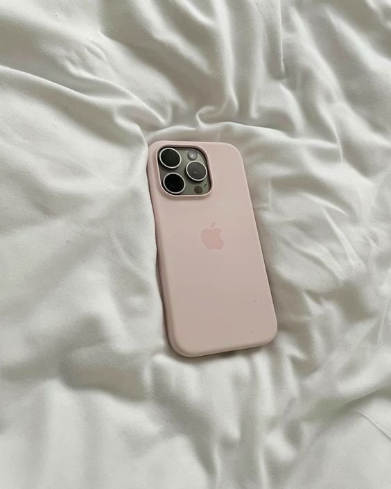 Pink iPhone with a case on white fabric