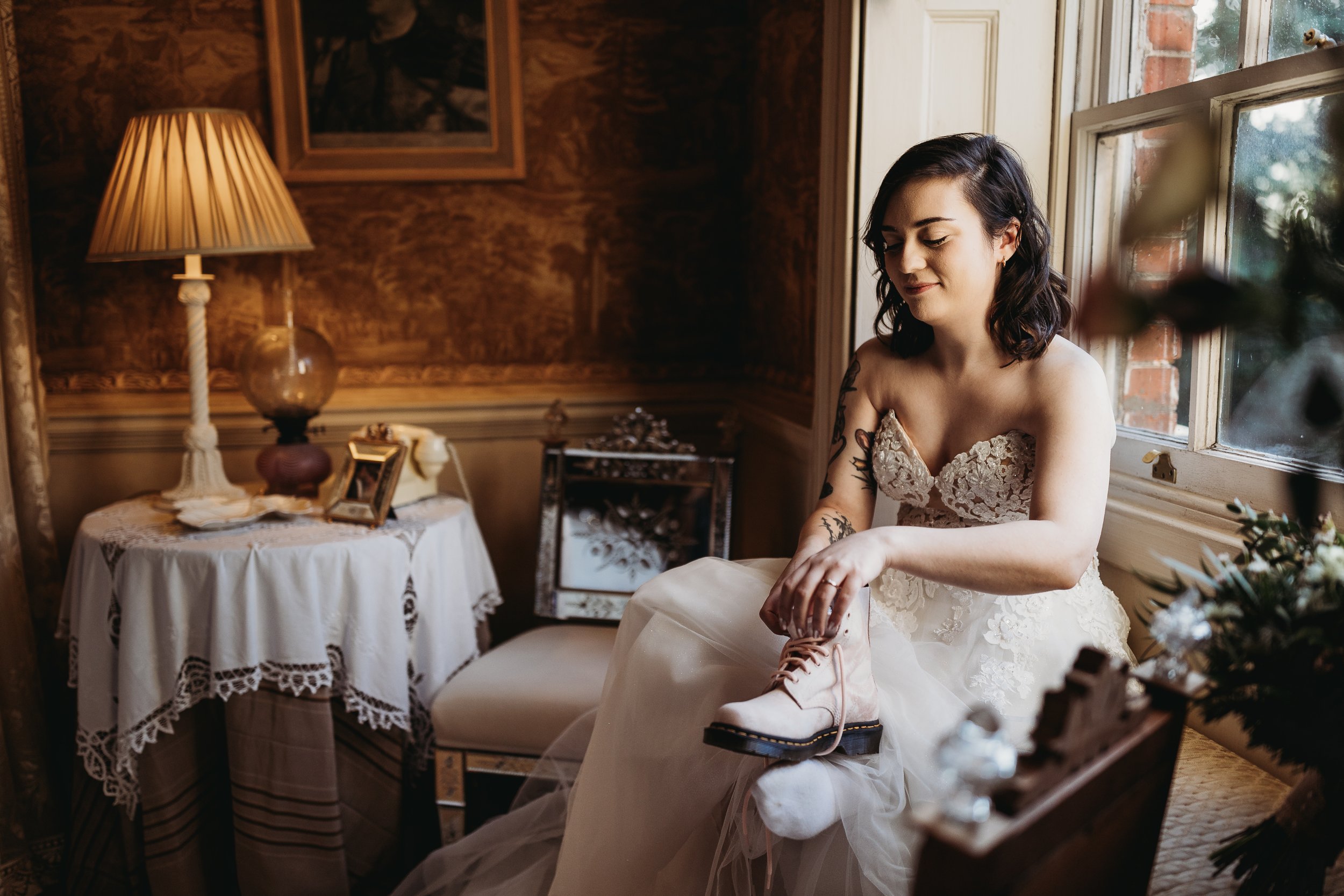 bride is putting her boots on at Island Hall wedding
