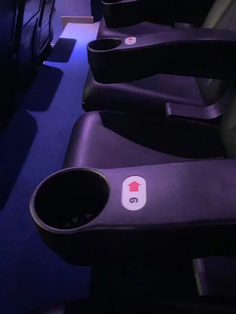 A cinema arm rest with a number and arrow