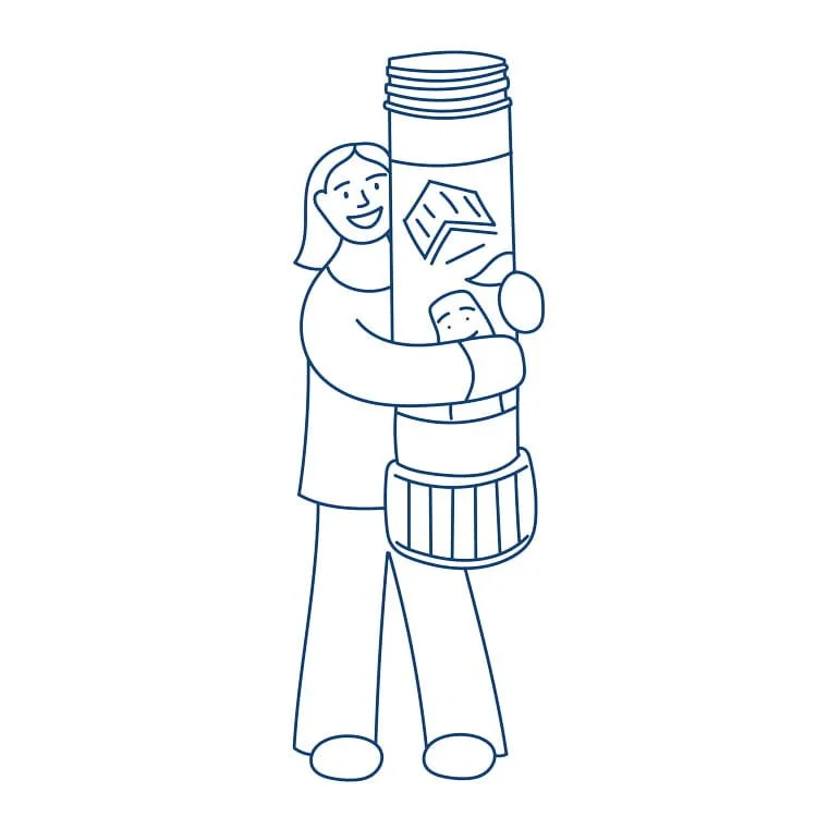 A woman smiling holding n oversized glue stick