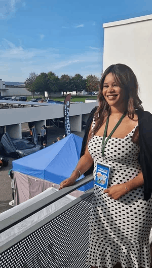  A woman stood smiling on a balcony above a race track 