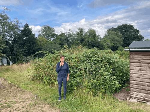  A woman smiling on an allotment plot 