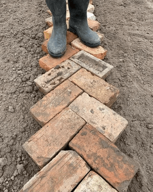  Two wellies stood on a line of bricks 