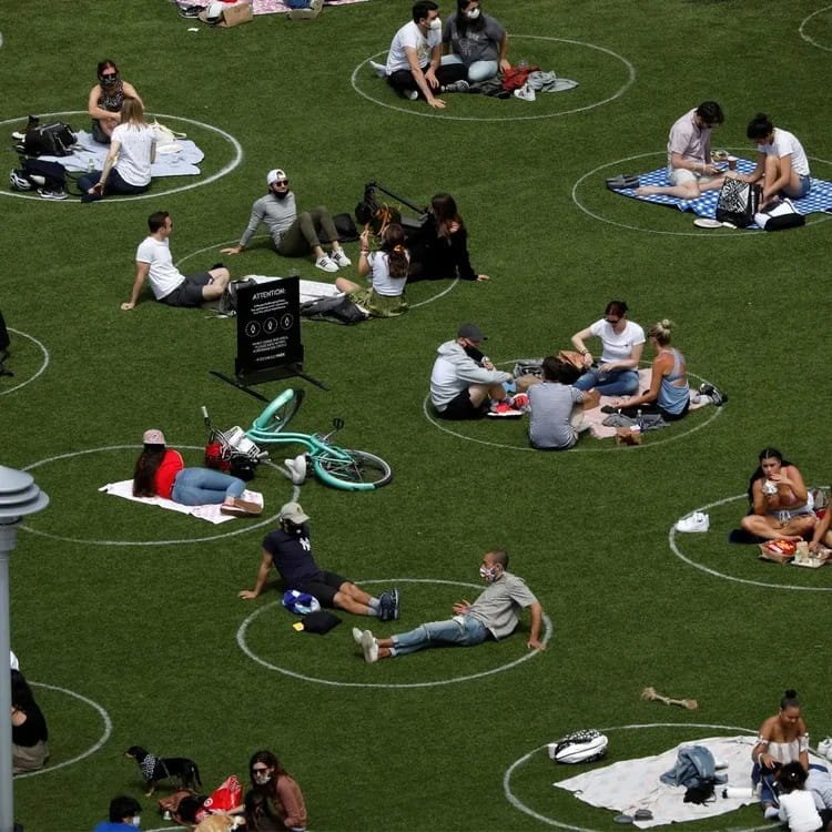 People sat in circles drawn on a grass field