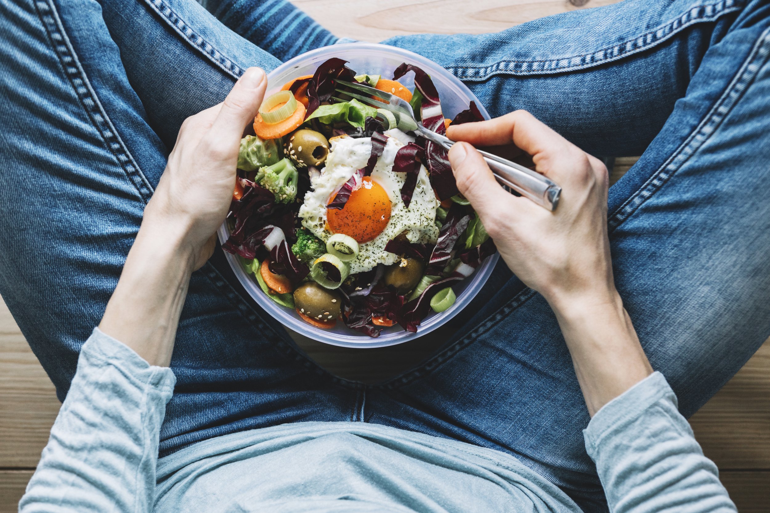 crop-person-eating-salad-with-fried-egg.jpg