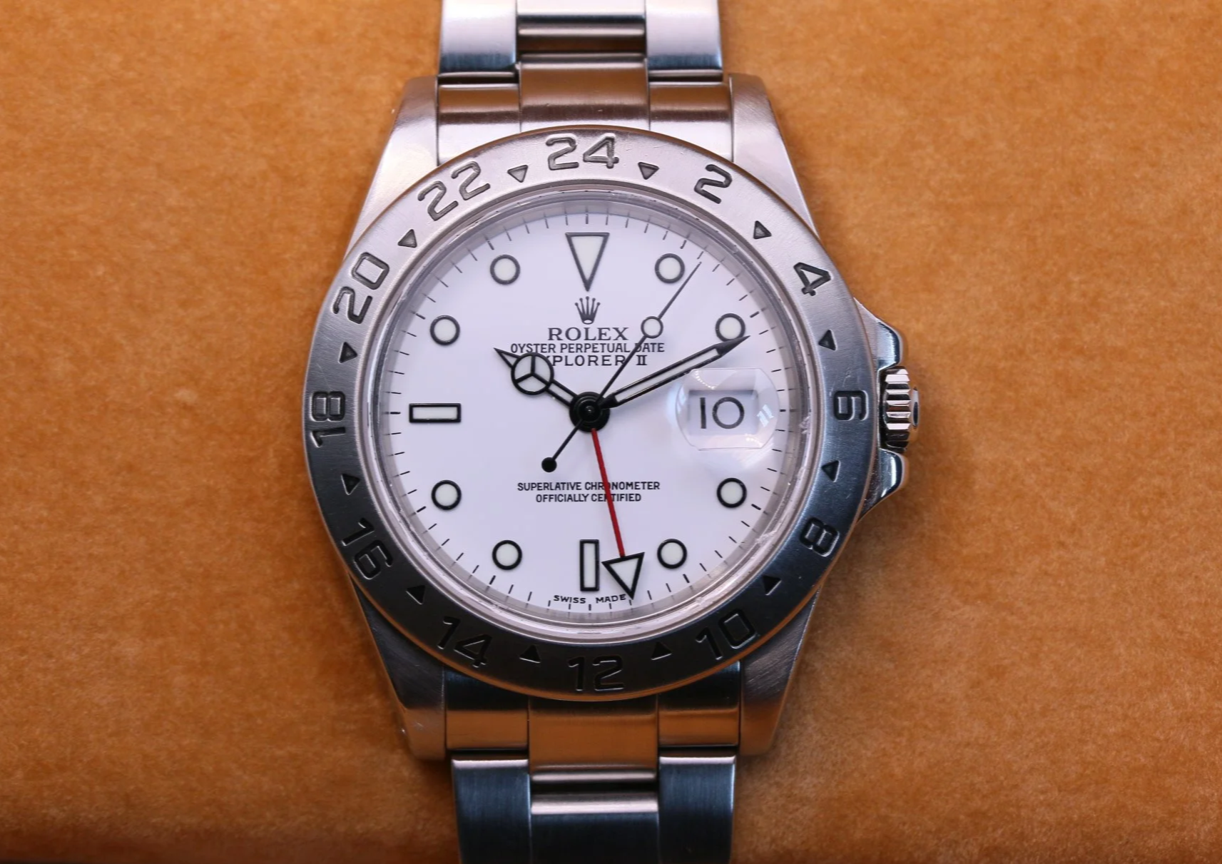 Close-up of a Rolex Explorer II wristwatch with a white dial and a stainless steel oyster bracelet.