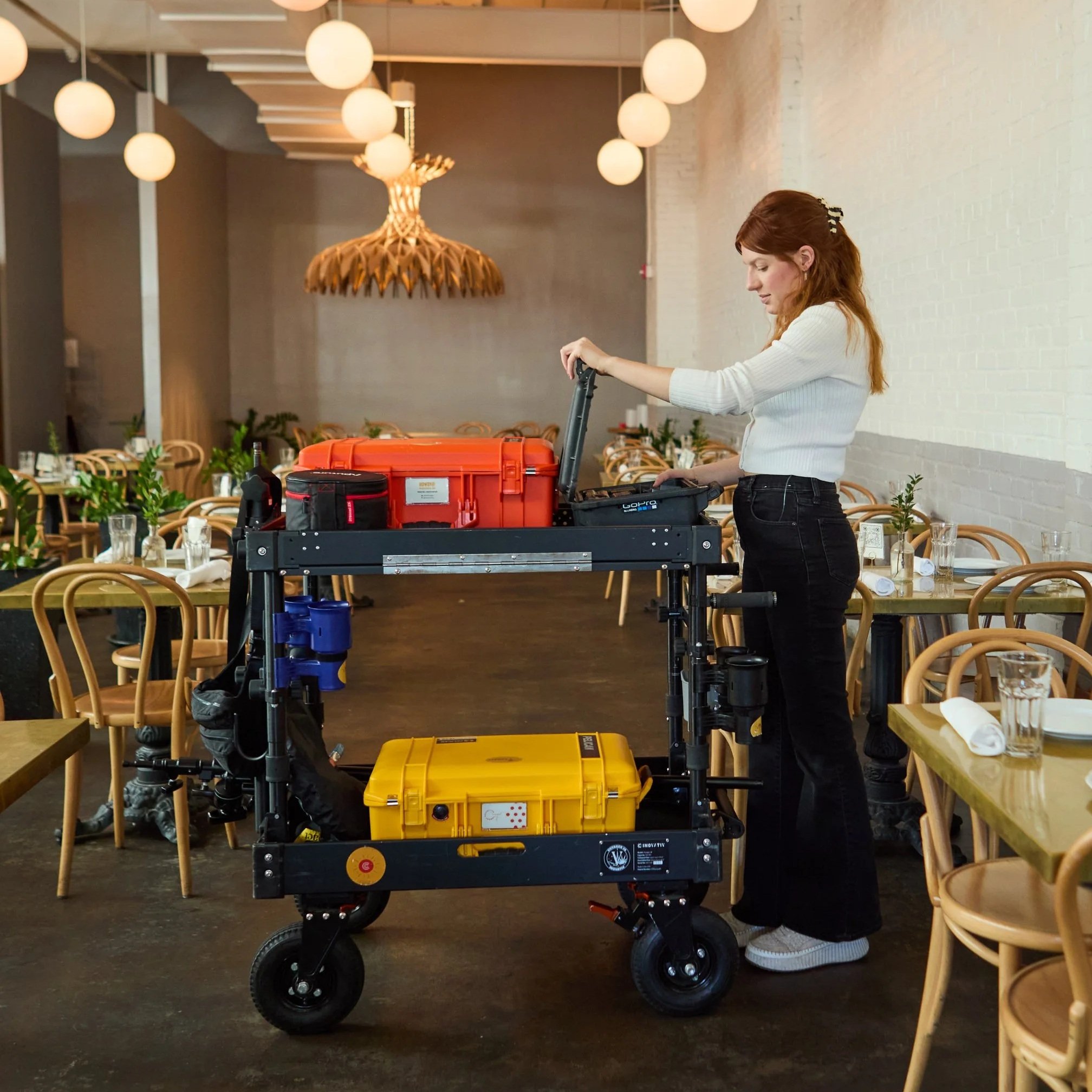 Inovativ cart being use by a digital tech woman, loaded with pelican cases, camera and digital tech equipment.