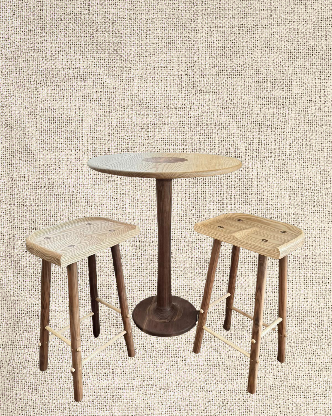 Wooden table with a round top and two matching wooden stools with square seats, set against a textured beige background.