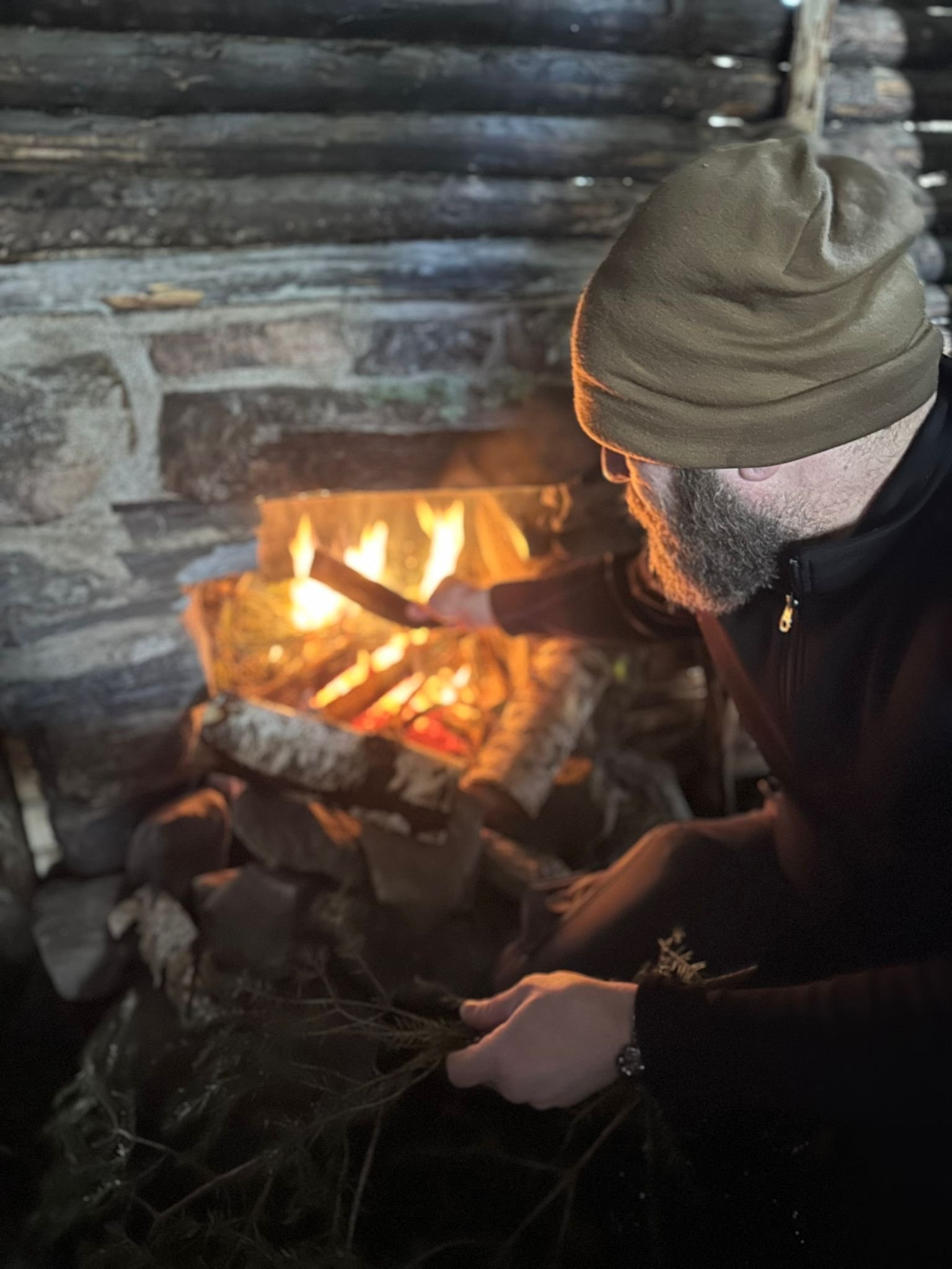 man feeding fire place set in stone.jpg