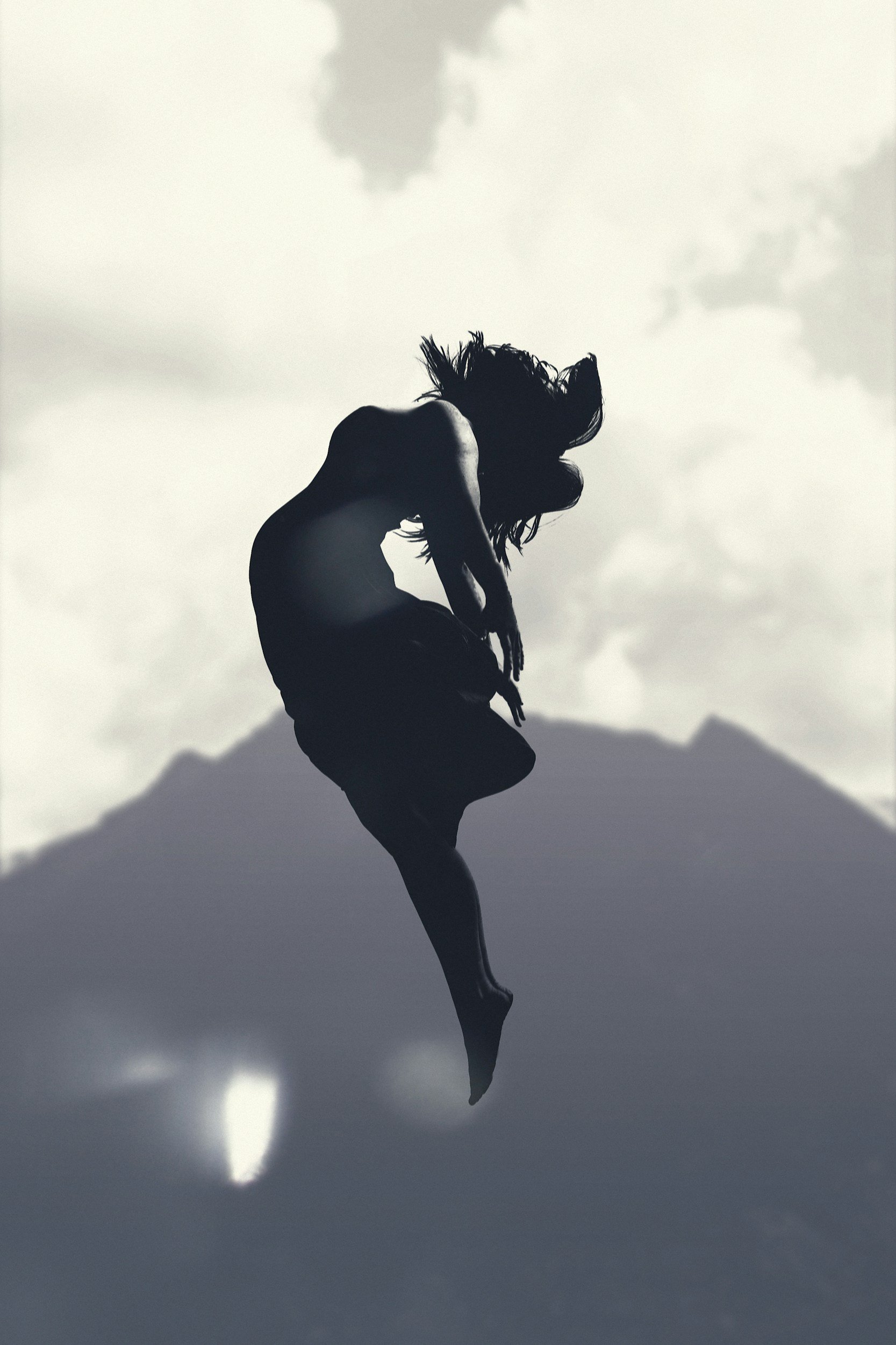 Black-and-white image of a woman floating upward: Alt: Black-and-white image of a woman floating upward, nervous system healing and emotional release after betrayal trauma San Antonio Texas