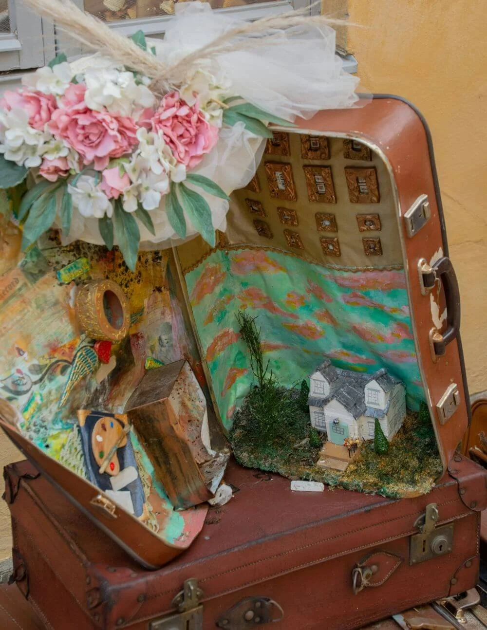 Open suitcase with a house and artist palette, online therapy available across Texas