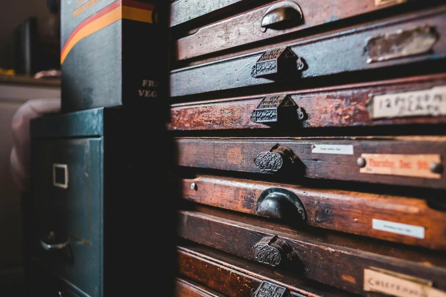 Two filing cabinets side by side, one vintage wood and one modern black, a quiet image of record and memory for trauma therapy with Rebecca Flores in San Antonio.