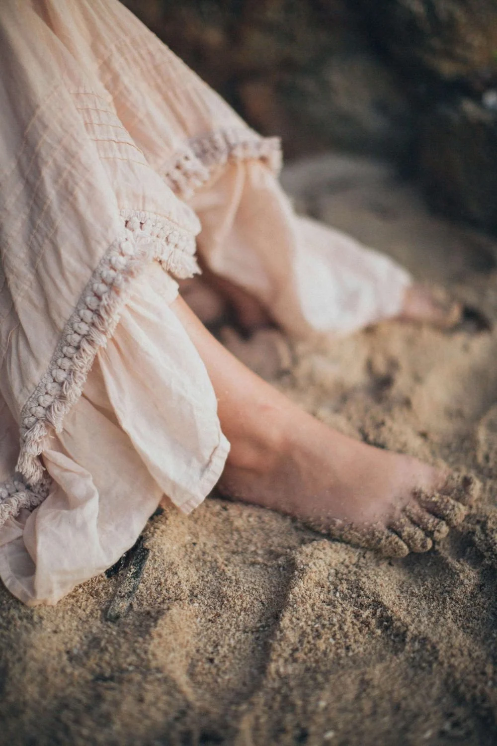 Woman sitting in sand with bare feet and a skirt, childhood trauma therapy women San Antonio Texas