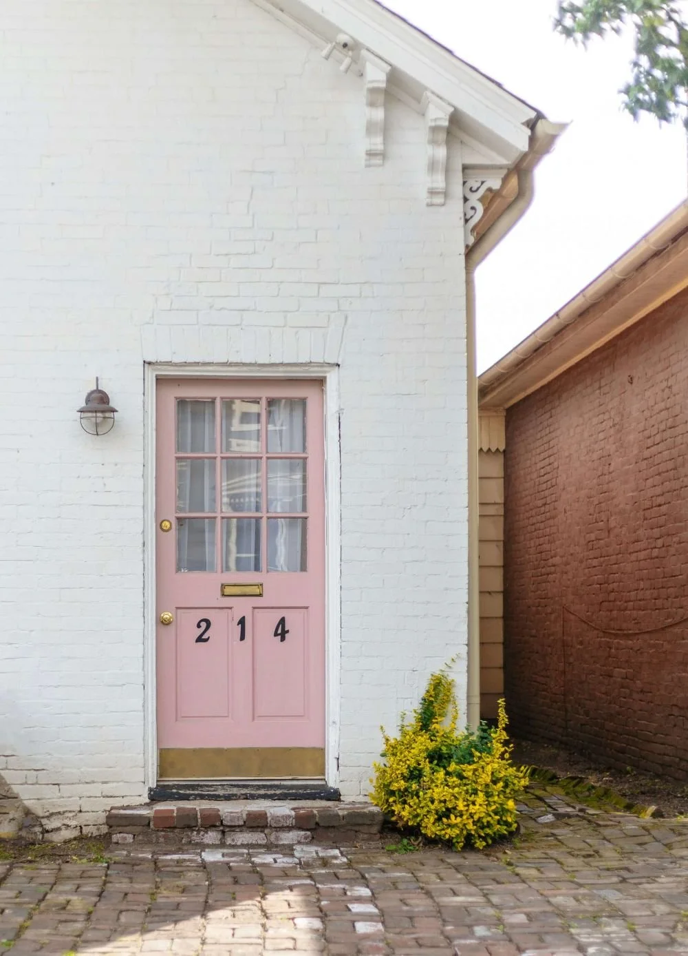 Soft pink door on white brick home - symbolizing access to inner healing through Brainspotting therapy