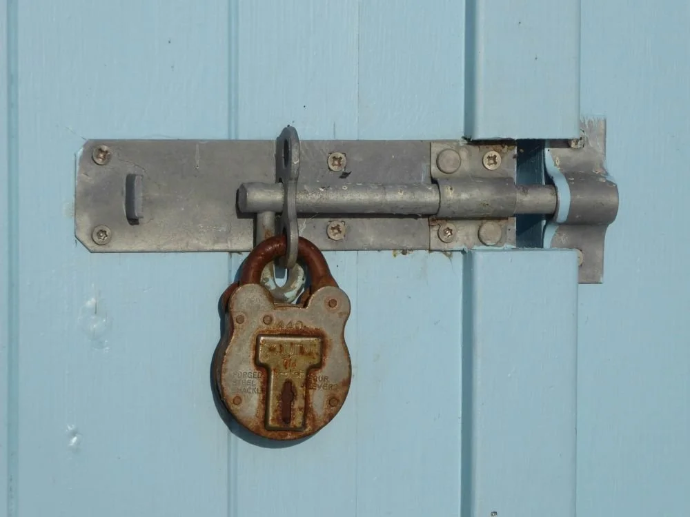 Close-up of antique lock on blue painted door, hypnotherapy for trauma and emotional healing San Antonio Texas