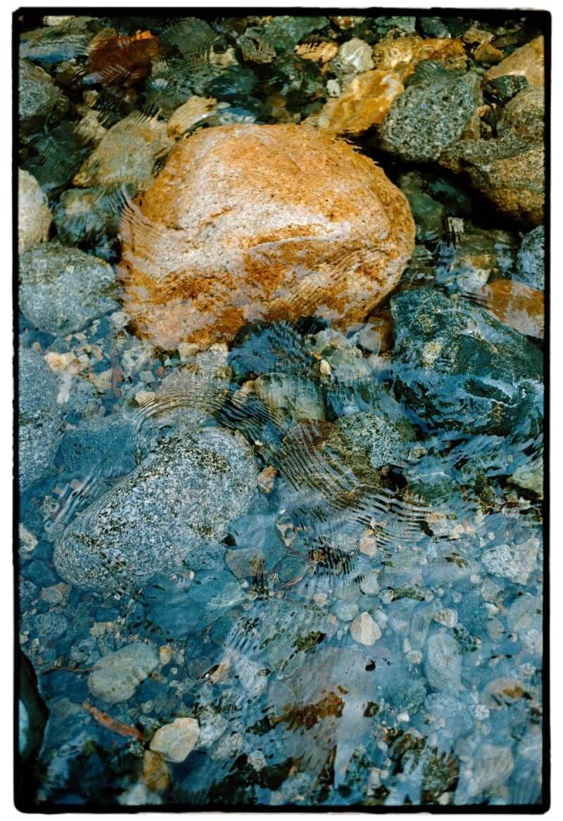 A smooth stone resting beneath clear still water, evoking calm and safe distance in online therapy for women in Oregon