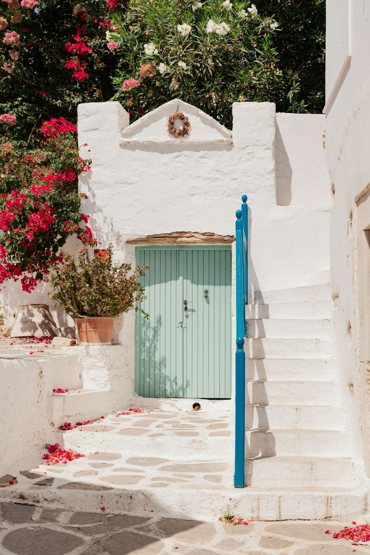 Unique stone home with two soft green doors, stone stairs, and flowering vines for online trauma and attachment therapy in Oregon with Rebecca Flores, LPC of Vita Counseling Center.