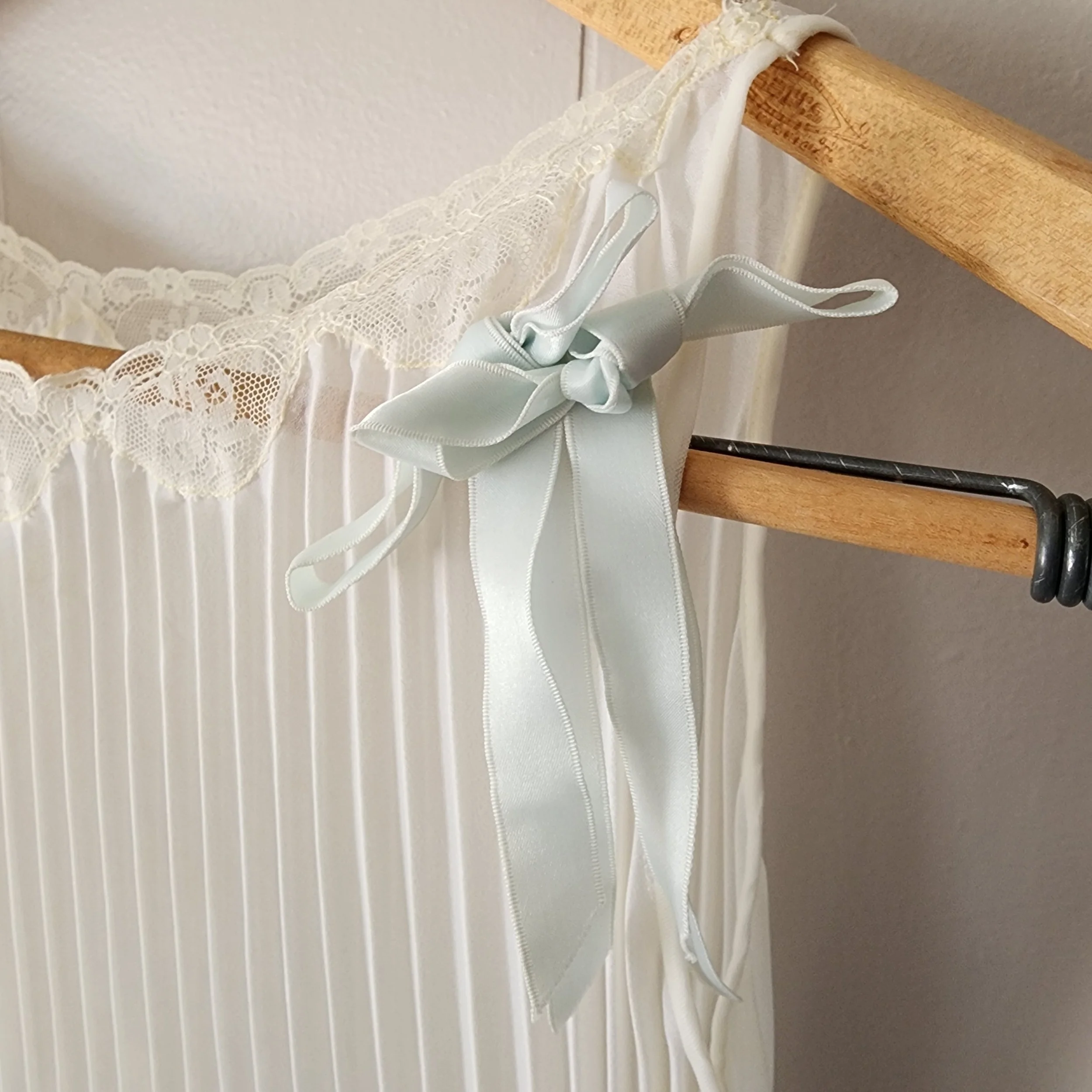 vertical pleating (very desirable)  soft ivory tone  lace neckline detail  original ribbon bow detail  flowy peignoir silhouette  appears lightweight nylon chiffon, collectiionpiece