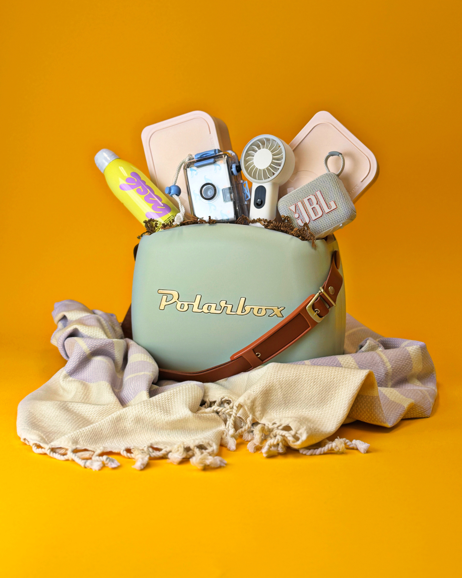 The Out of Office Gift, featuring a Polarbox cooler, Bask Sunscreen, Kaftan, Waterproof camera, and other sunny day essentials.