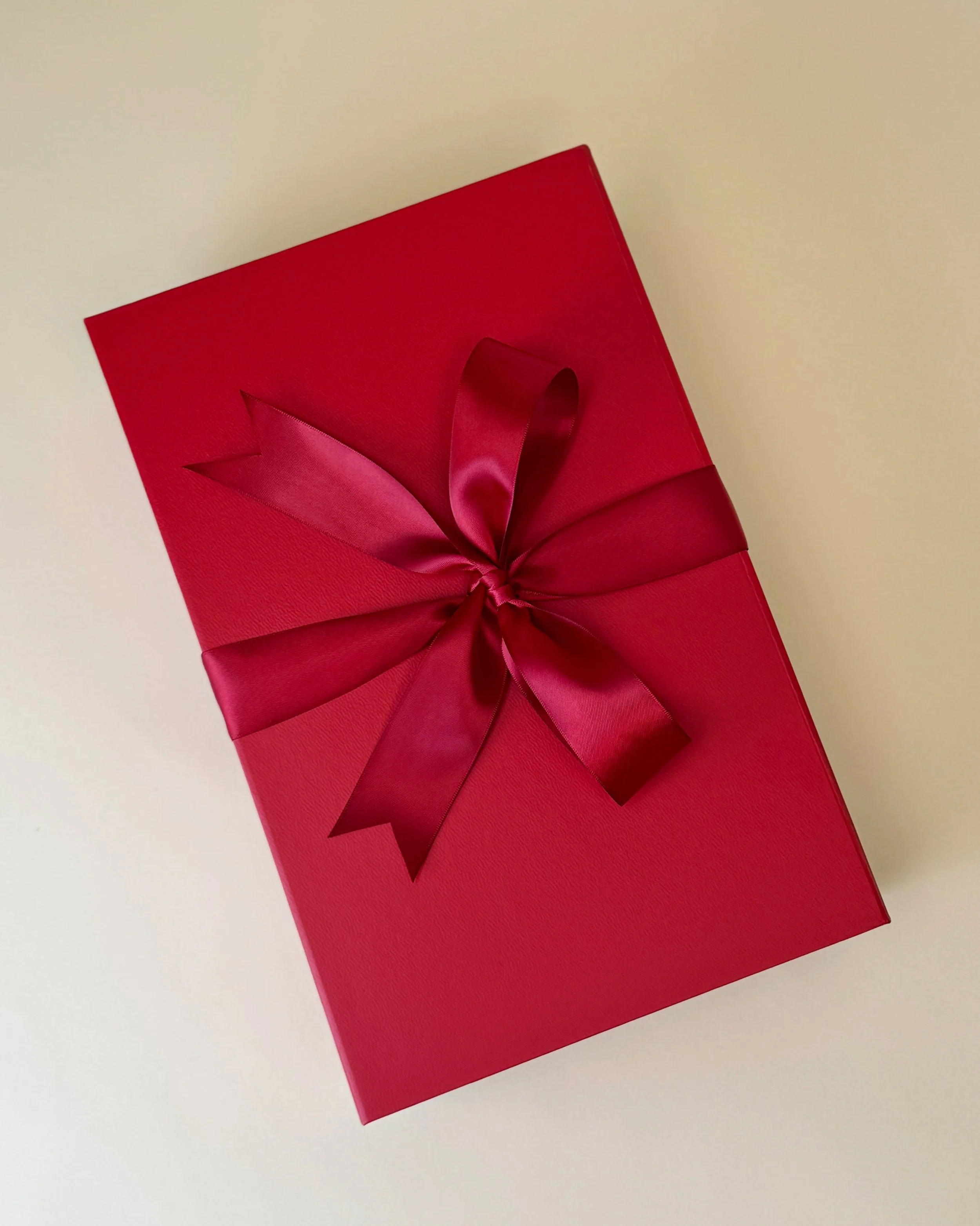 Red gift box, gift wrapped with red satin ribbon