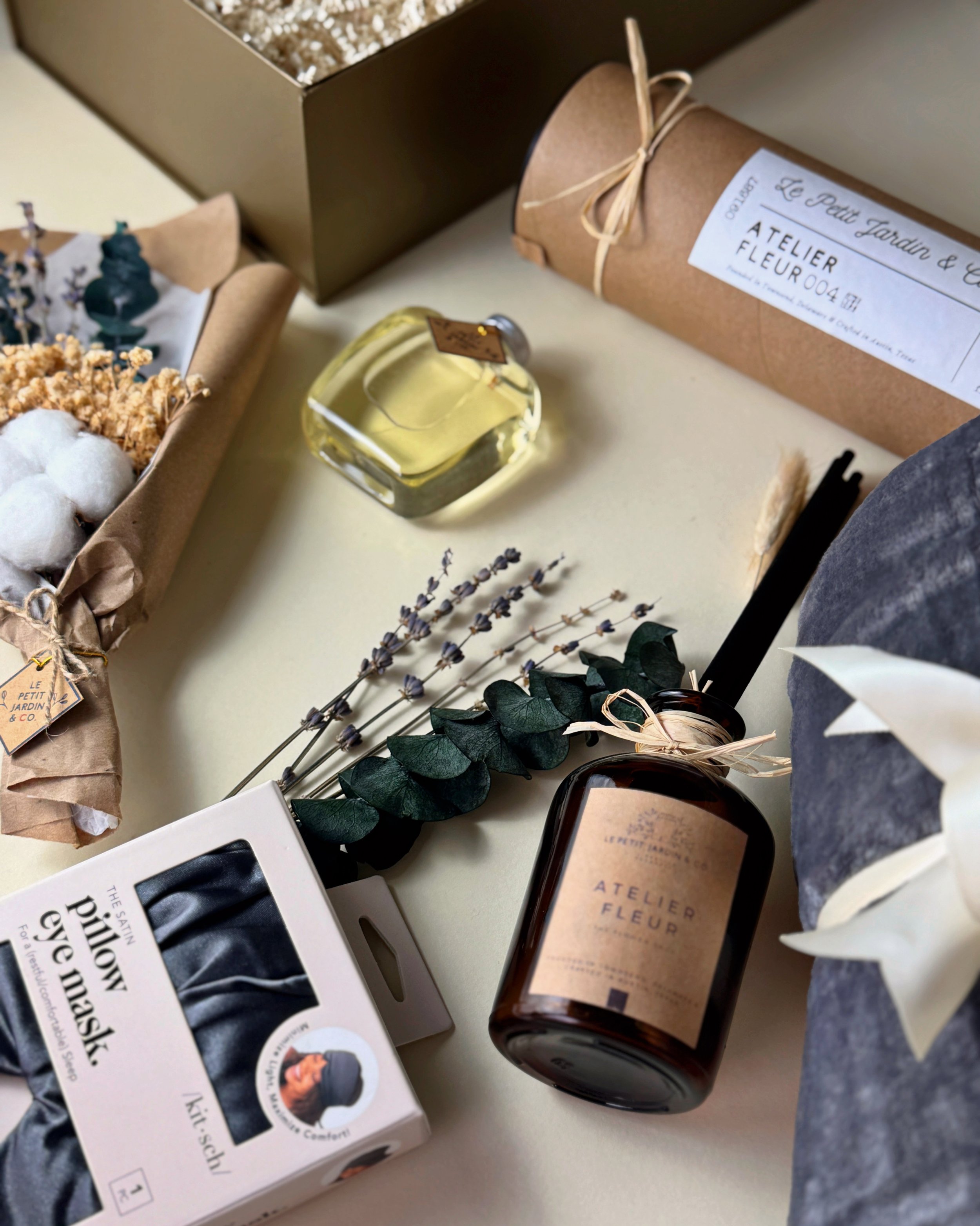 The Grand Maison Gift, featuring a cozy throw blanket, Le Jardin Reed Diffuser, Fragrance Oil, and Dried Bouquet. Gift wrapped with ribbon.
