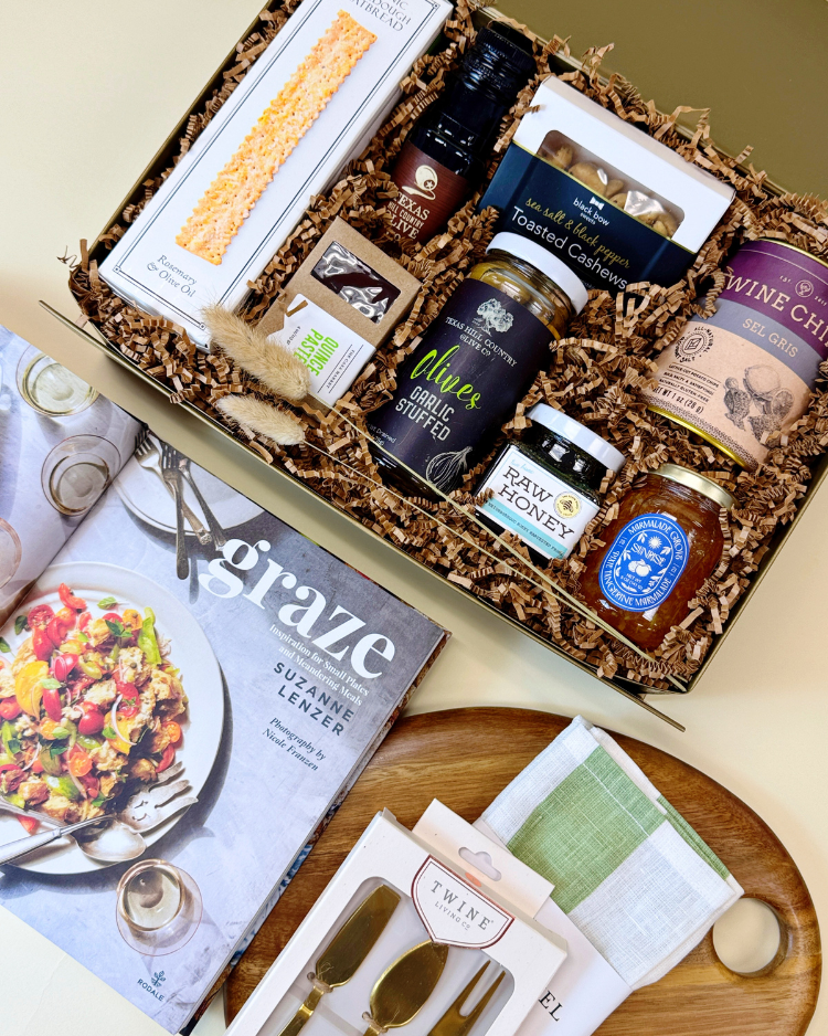 A close up view of the contents of Countryside Graze, featuring premium hosting essentials along with gourmet snacks and treats to enjoy with a charcuterie spread.