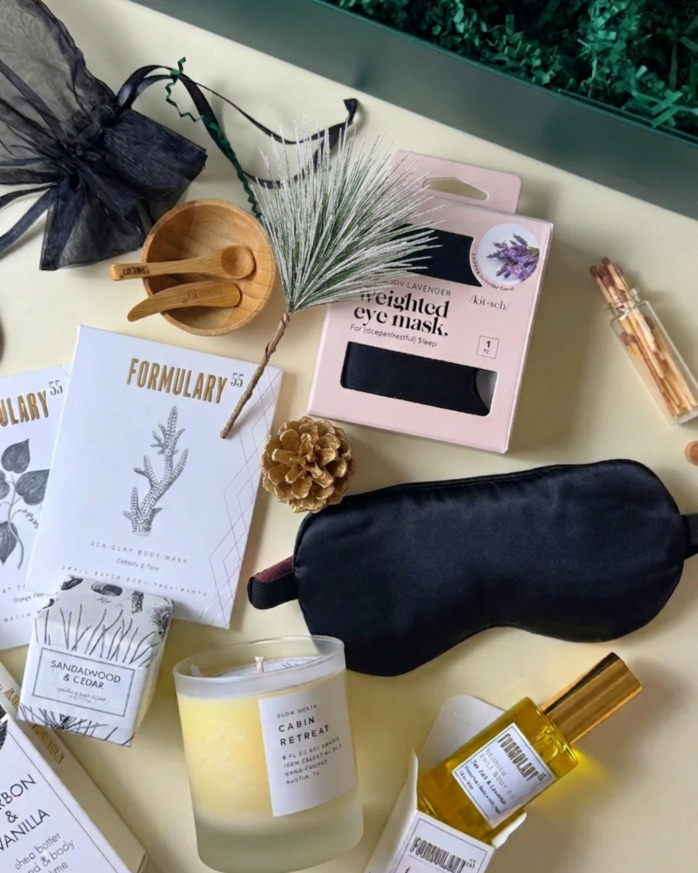 The Winter Reset Gift with bath and body essentials, candle, weighted eye mask, matches, and bamboo treatment tools in a green gift box.