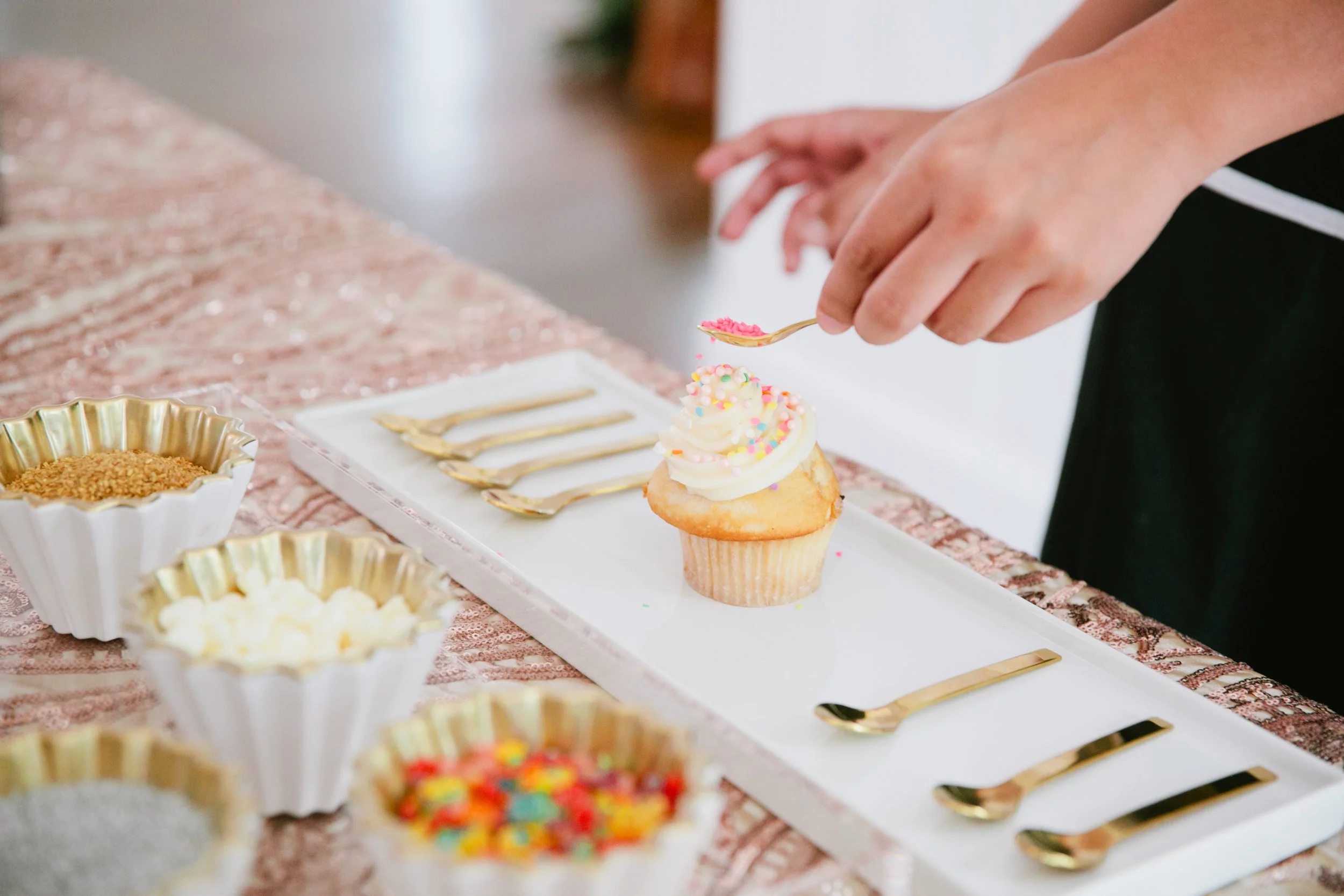 Attendant serves custom cupcake at a Cupcake Bar in Austin Texas