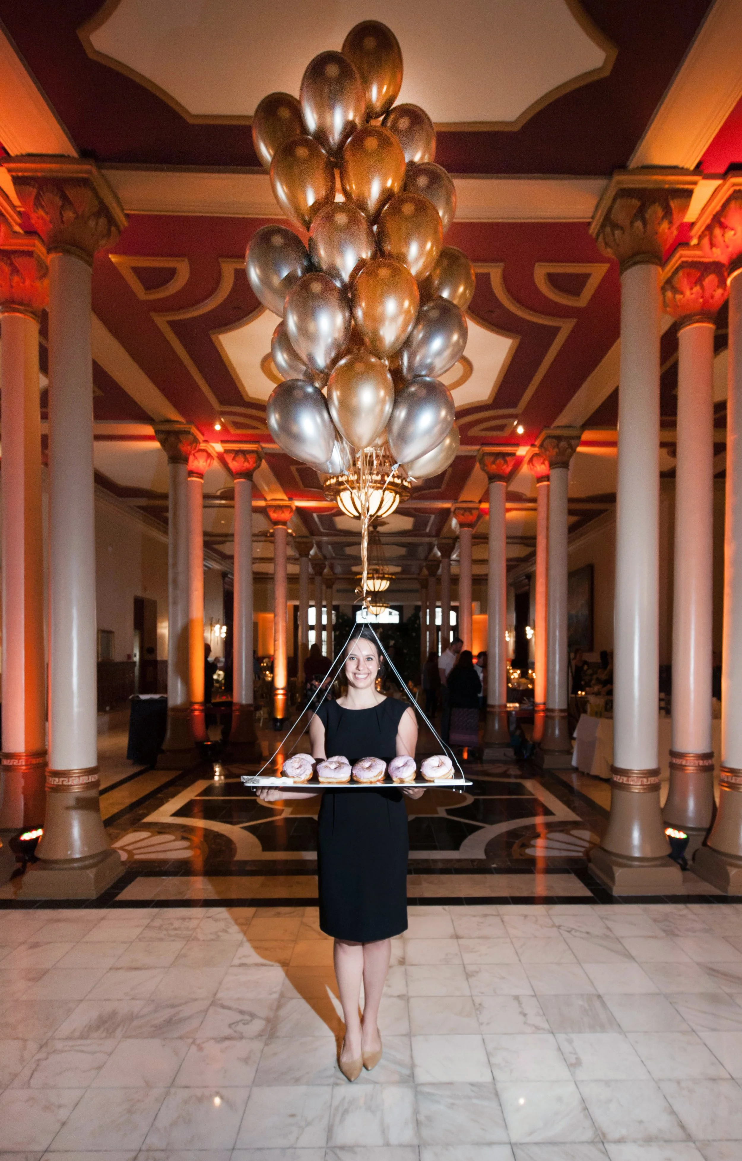 TCB's server holds a floating tray of doughnuts at an Austin, TX wedding.