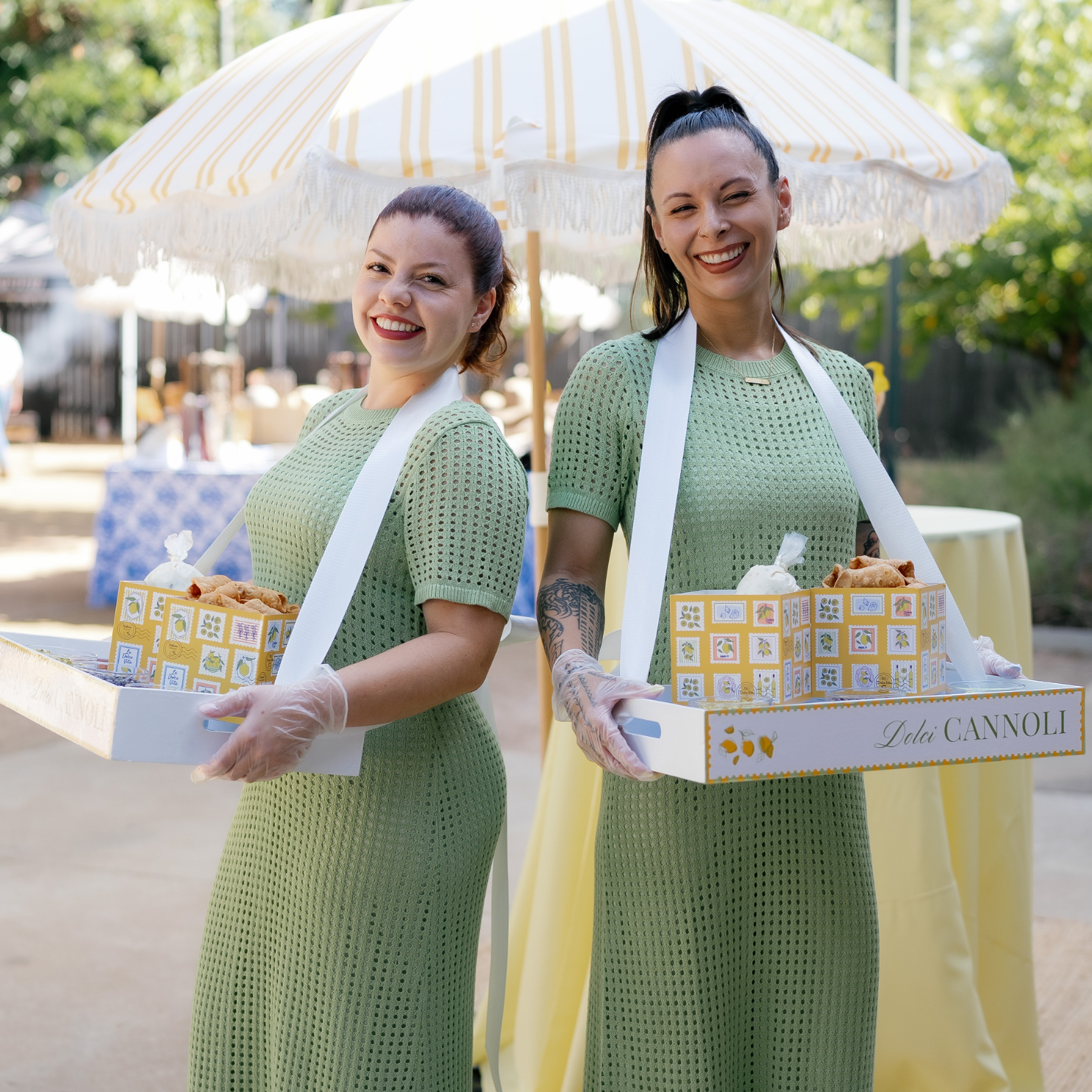 Two Roaming Cannoli Bartenders serve custom-made cannoli to guests at an Italian Amalfi Coast-themed event in Austin