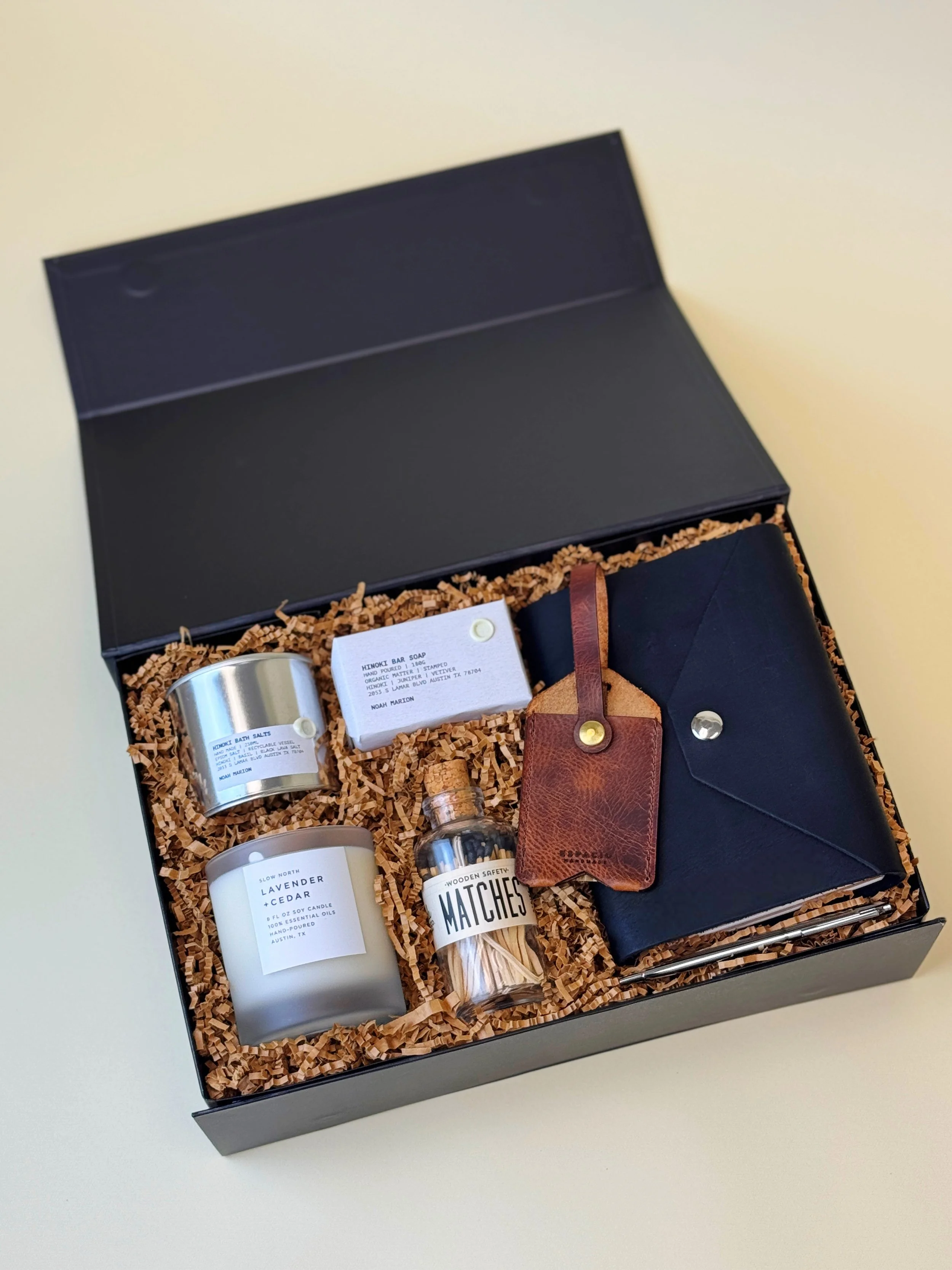 The Artisan luxury Austin gift box featuring leather goods, Slow North candle, Noah Marion artisan soap and bath salts, and wooden matches from Texas makers.