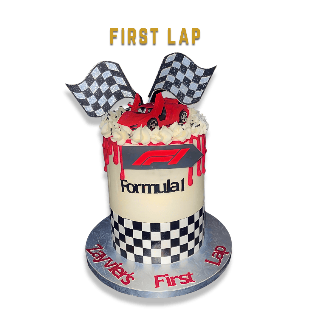 Race car themed birthday cake with Formula 1 logo, checkered flags, and a red race car topper, with 'First Lap' written on top and on the cake base.