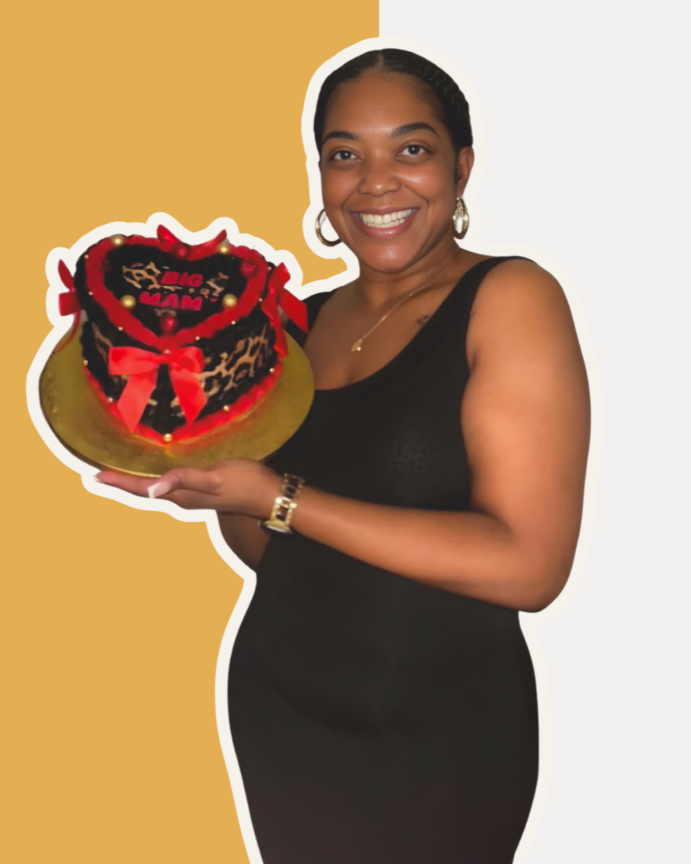 Woman smiling and holding a decorated cake with edible leopard print, red ribbons, and a message that says 'Big Mom'.