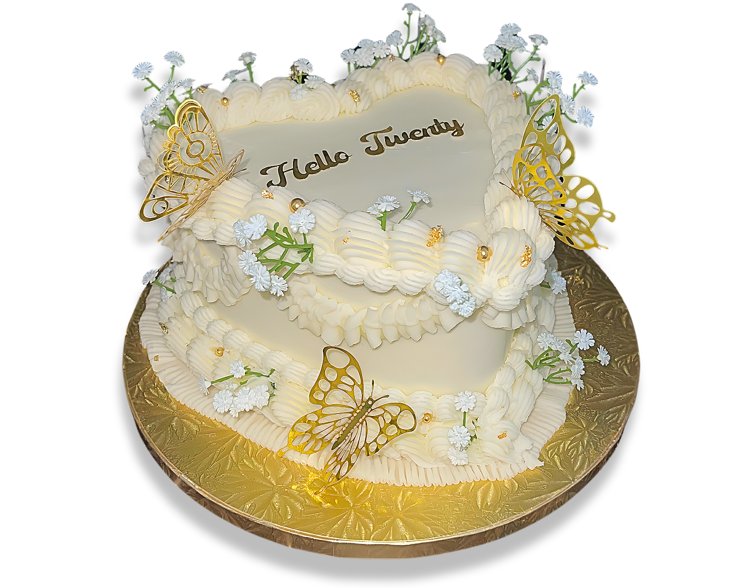 A decorated birthday cake with white icing, small white flowers, golden butterfly decorations, and the message "Hello Twenty" written on top. The cake is on a gold-colored base.