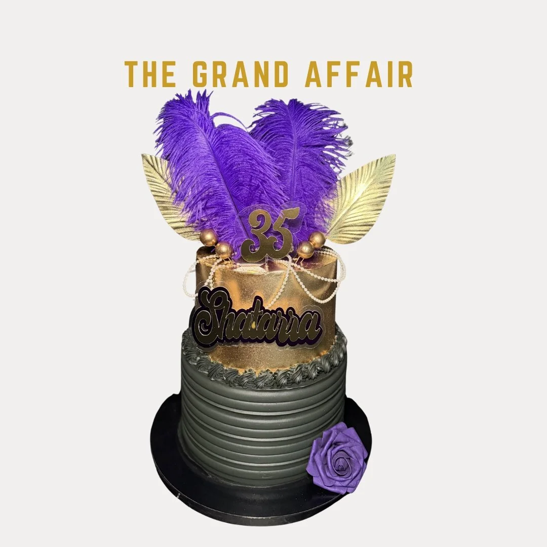 A two-tiered birthday cake with purple and gold decorations. The top tier features purple feathers, gold leaves, and a "35" topper, with a sign reading "Shatarra." The bottom tier is decorated with horizontal silver-gray lines and a purple rose at th