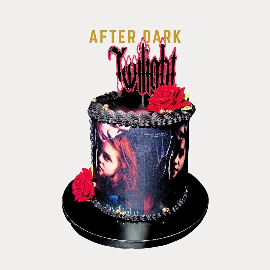After Dark Cake is a  Twilight Movie black themed birthday cake with purple and black frosting, red roses, and a topper that reads 'After Dark'. The cake features images of two women on the sides and a decorative skelton-like design on top.