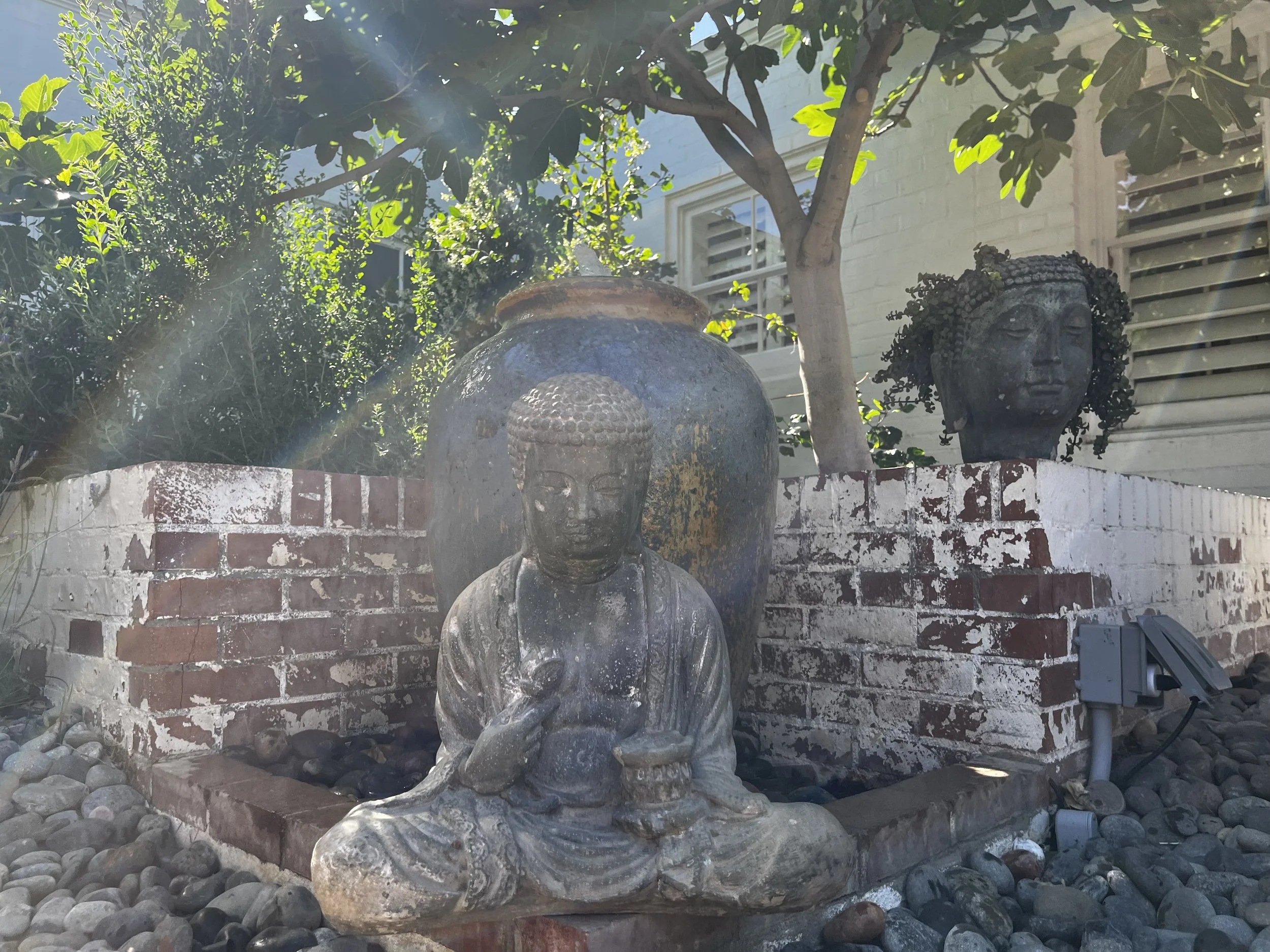 outdoor green entrance with buddha statues