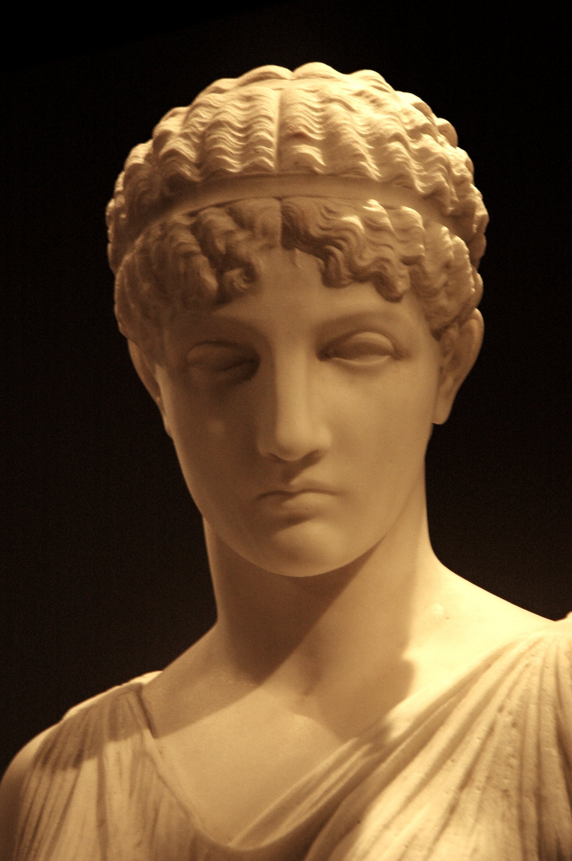 Marble sculpture of a woman’s head and upper torso in classical style with smooth features and idealized proportions