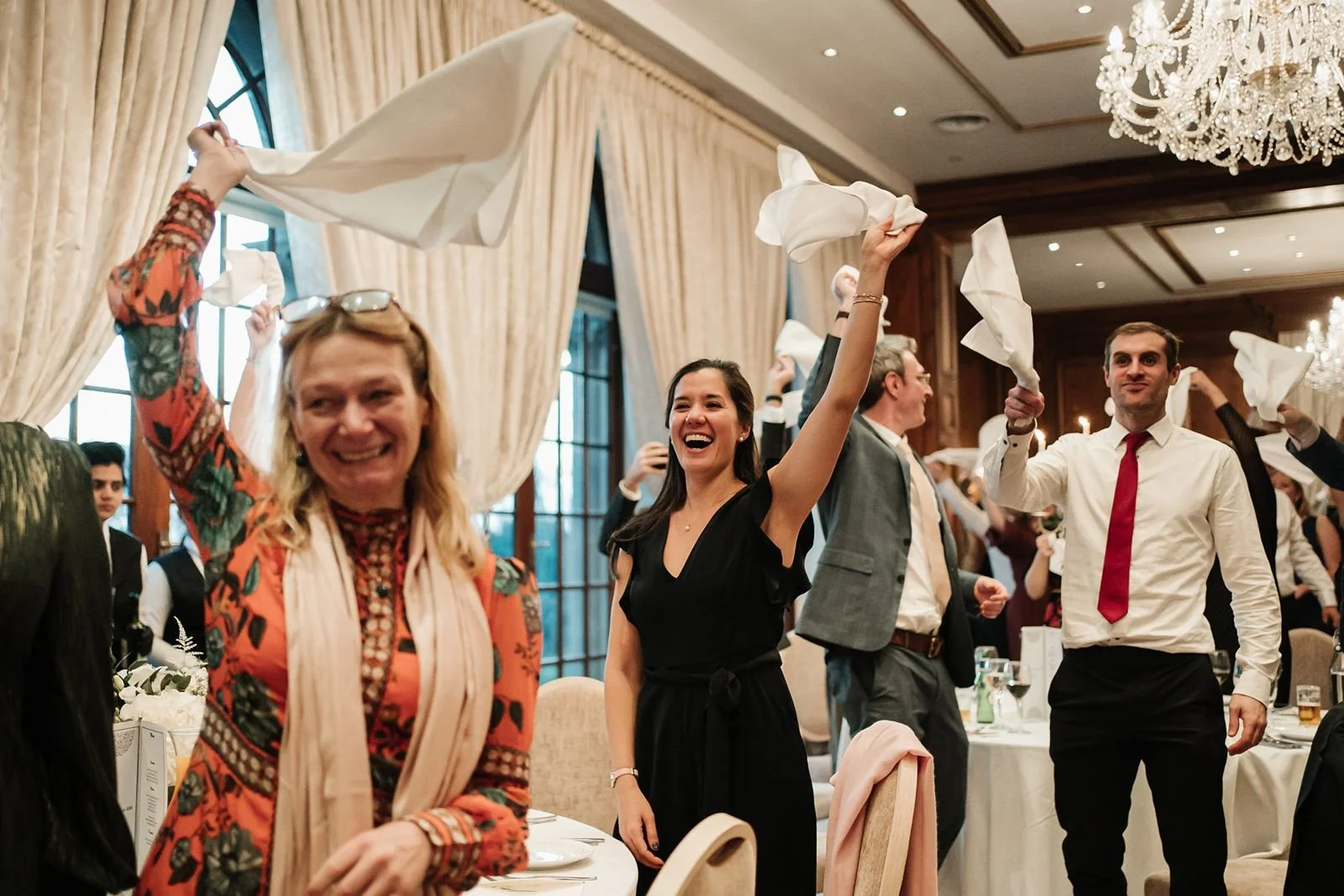 Wedding guests standing waving napkins for couple entrance