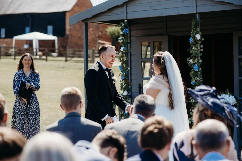 Celebrant leading fun ceremony with groom sticking his tongue out at the bride