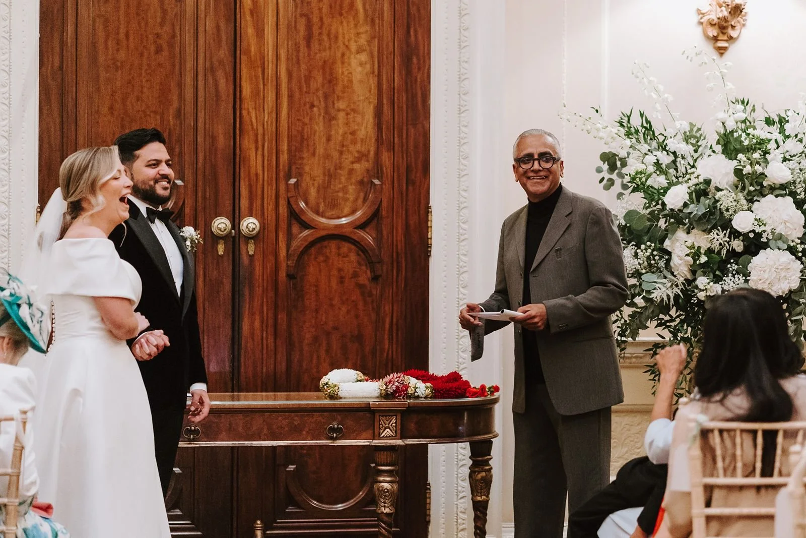 Married couple stand enjoying uncle reading during ceremony