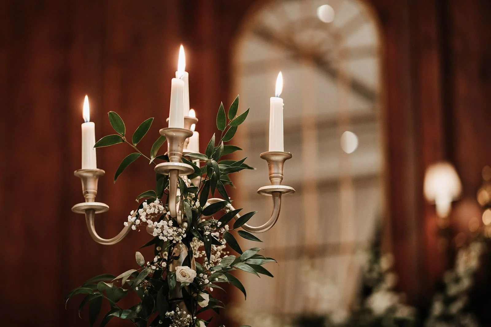 Candles in a candelabra with foliage table centre
