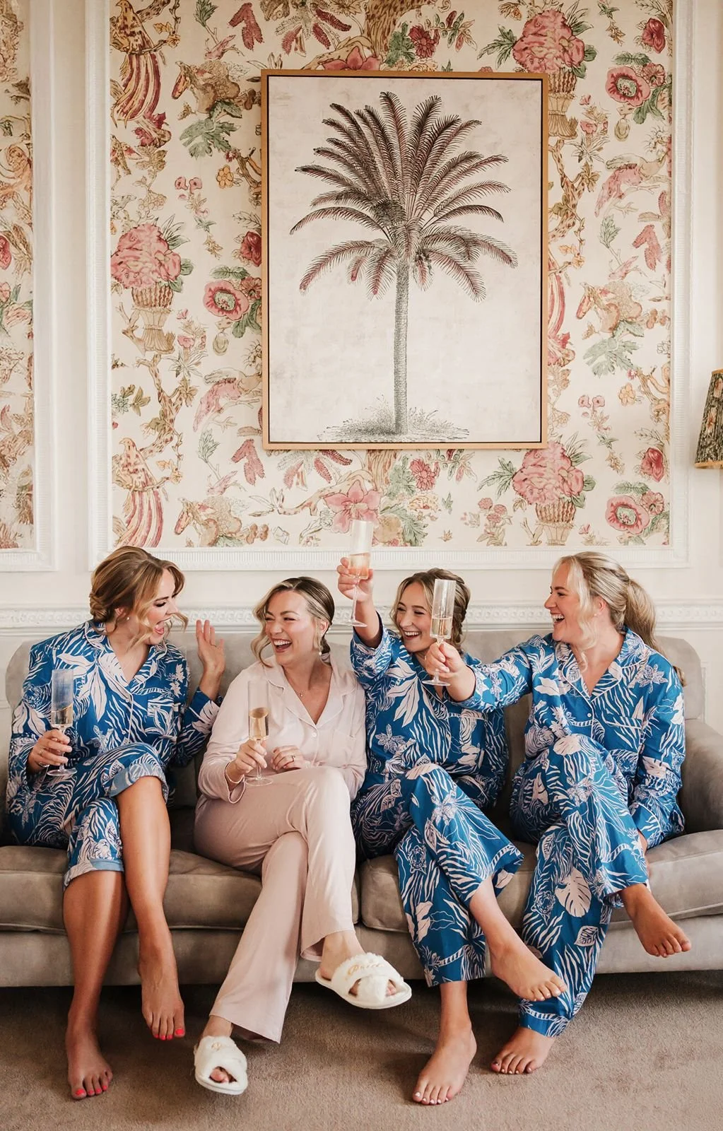 Bride laughing and toasting with bridesmaids in matching pyjamas