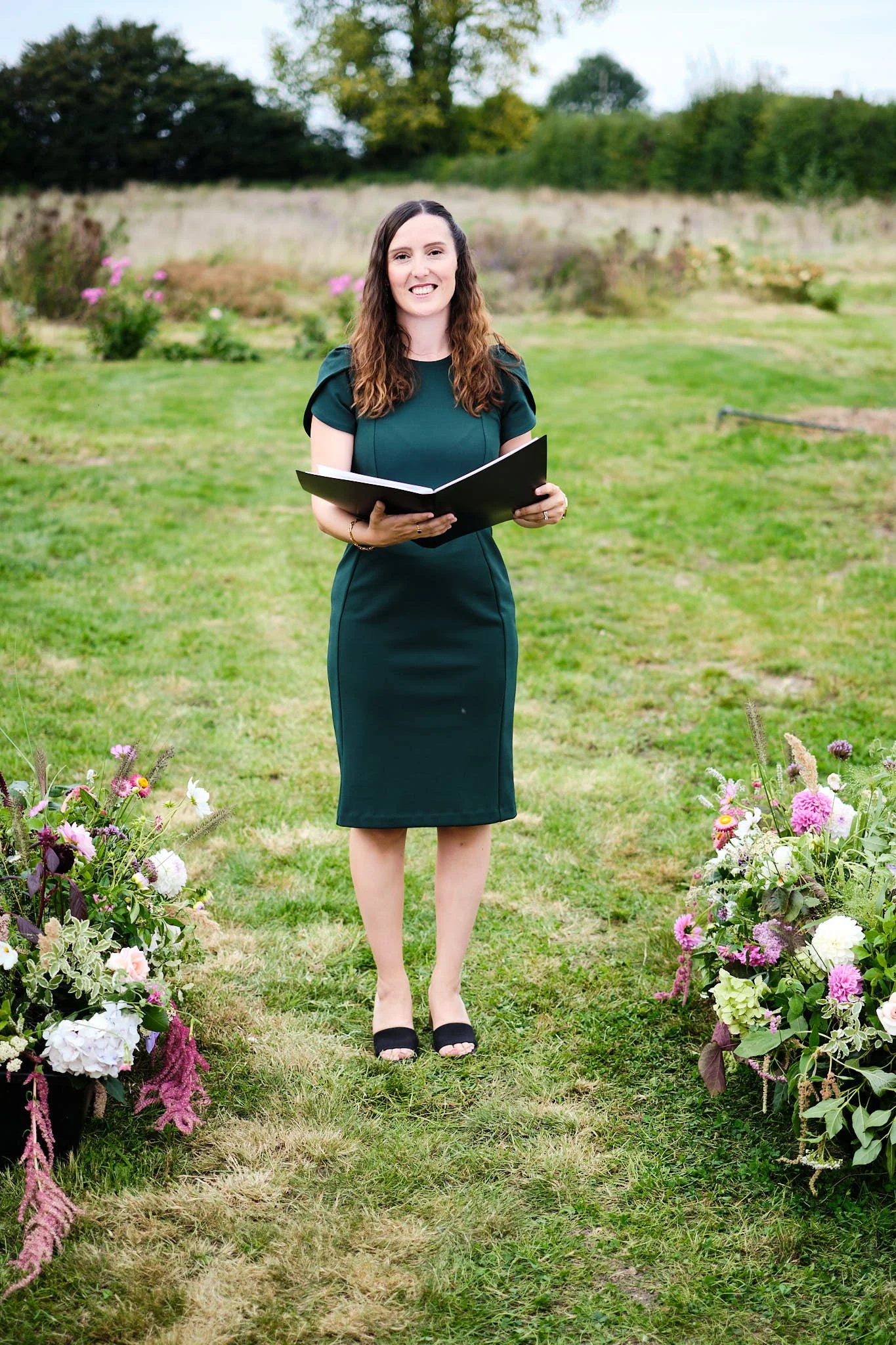 Wedding celebrant in outdoor ceremony holding folder