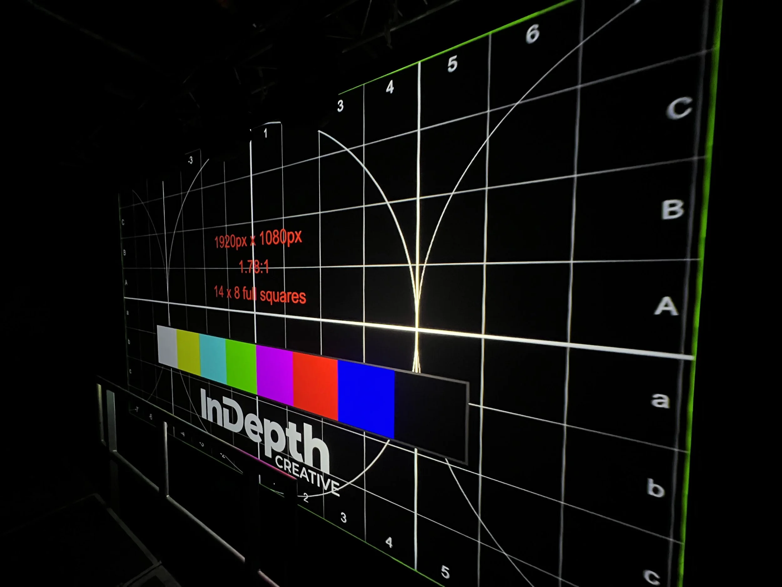Projection mapping alignment test pattern with InDepth Creative branding on a large screen