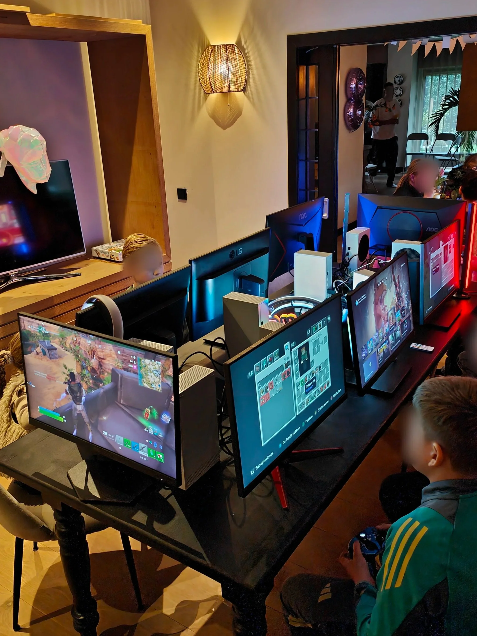Kinderen die videospelletjes spelen op meerdere computers in een woonkamer of gamingruimte.